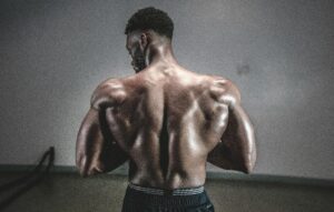 A shirtless man displaying his muscular back, showcasing strength and fitness.